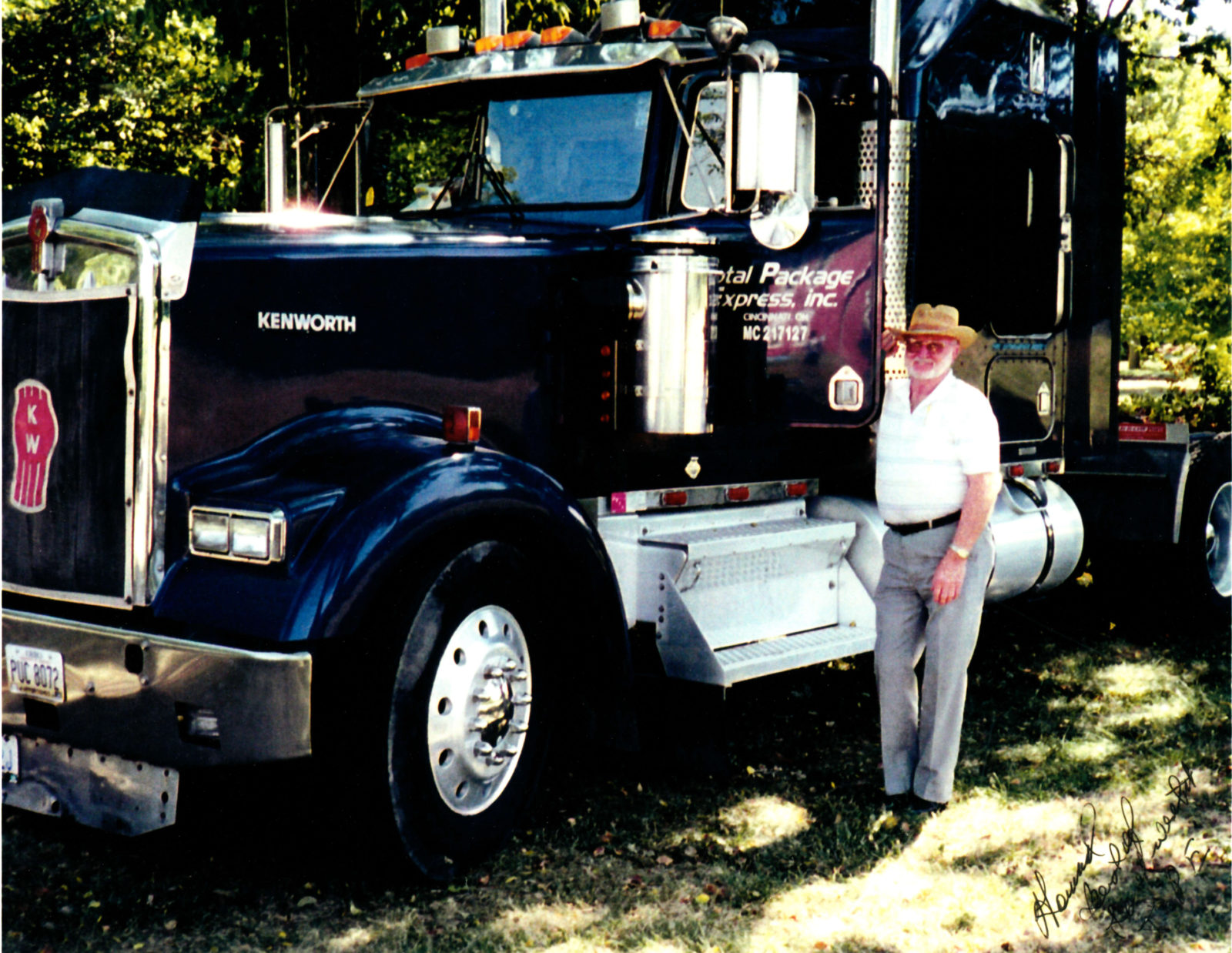 Man standing next to black Kenworth semi-truck